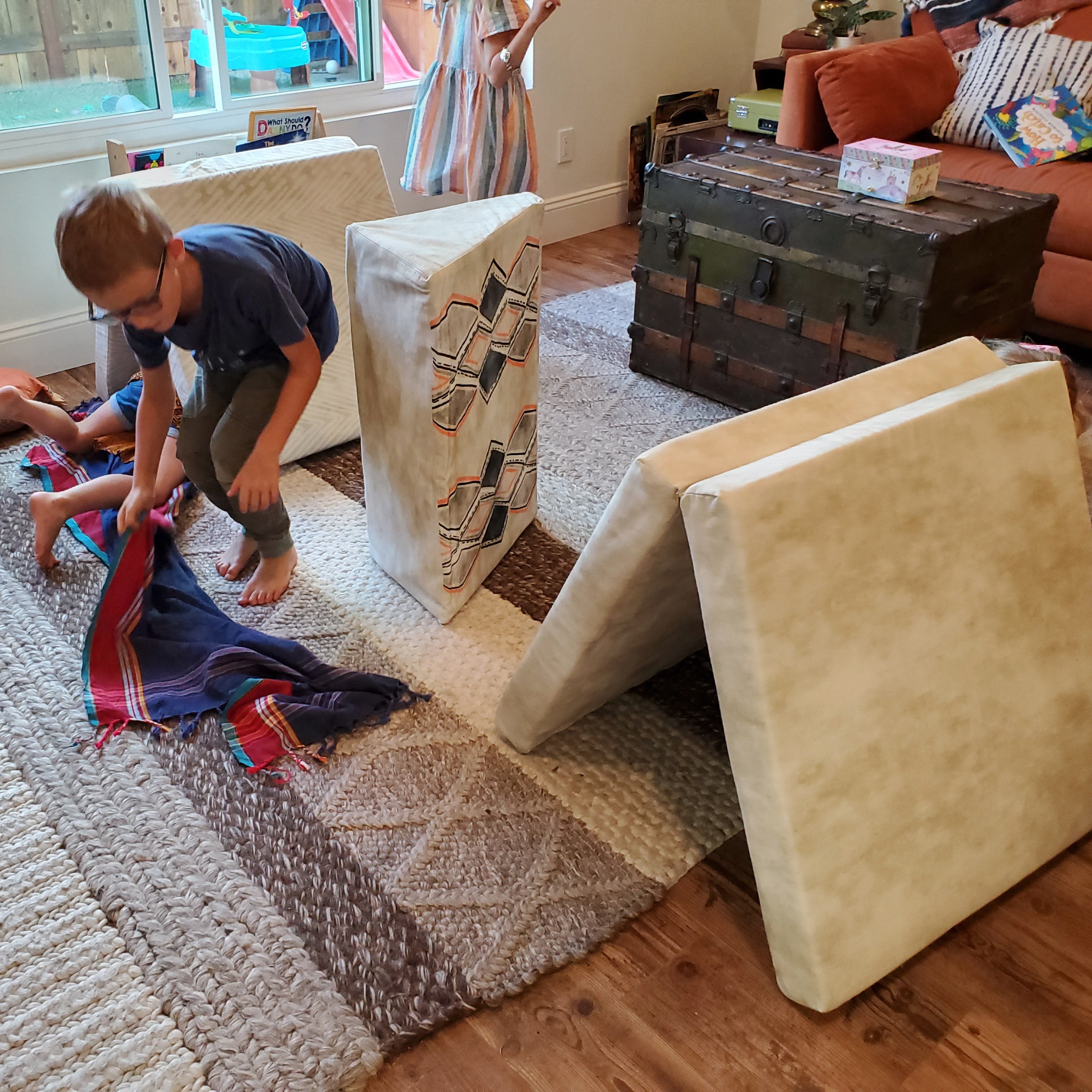 Child playing with a toy on a rug in a living room