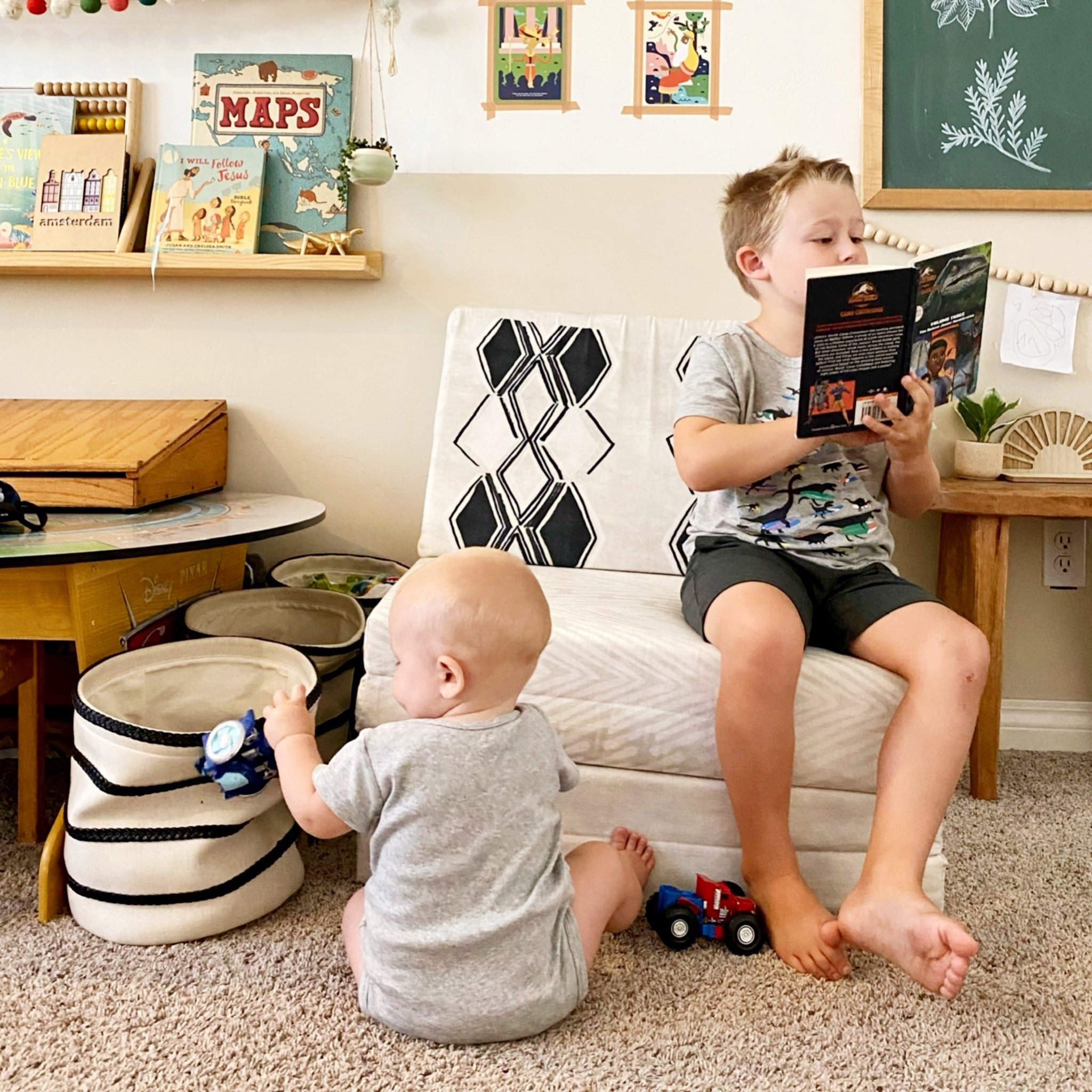 Two children in a playroom with books and toys